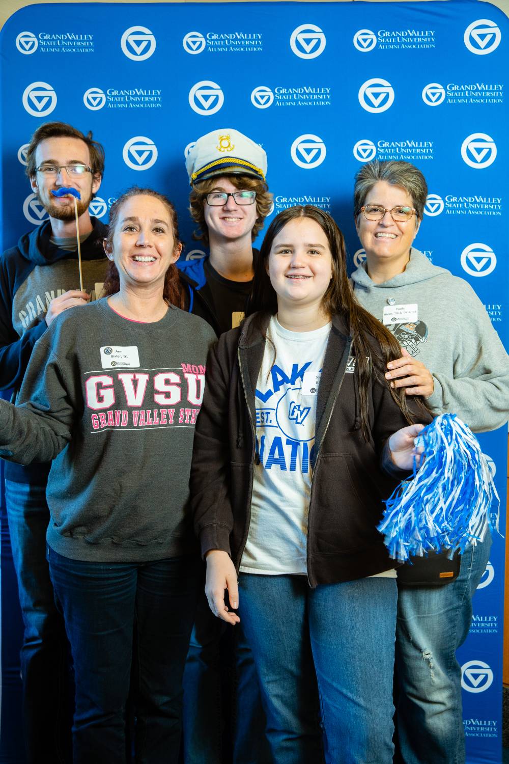 An alumni posing for a photo with her family.